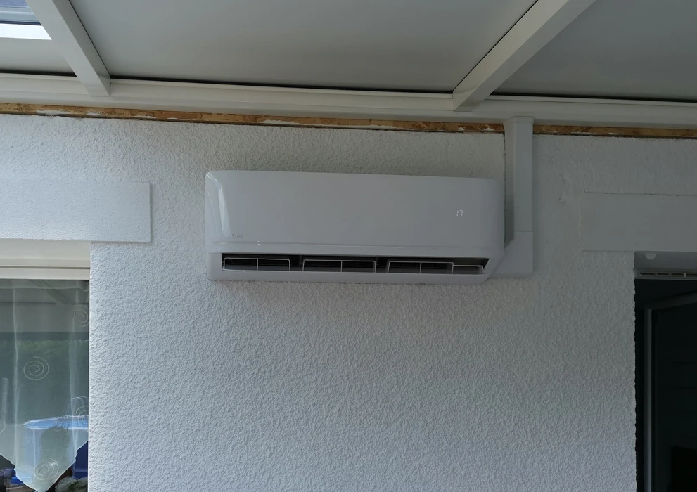 Intérieur résidentiel avec climatiseur mural blanc installé sur mur texturé