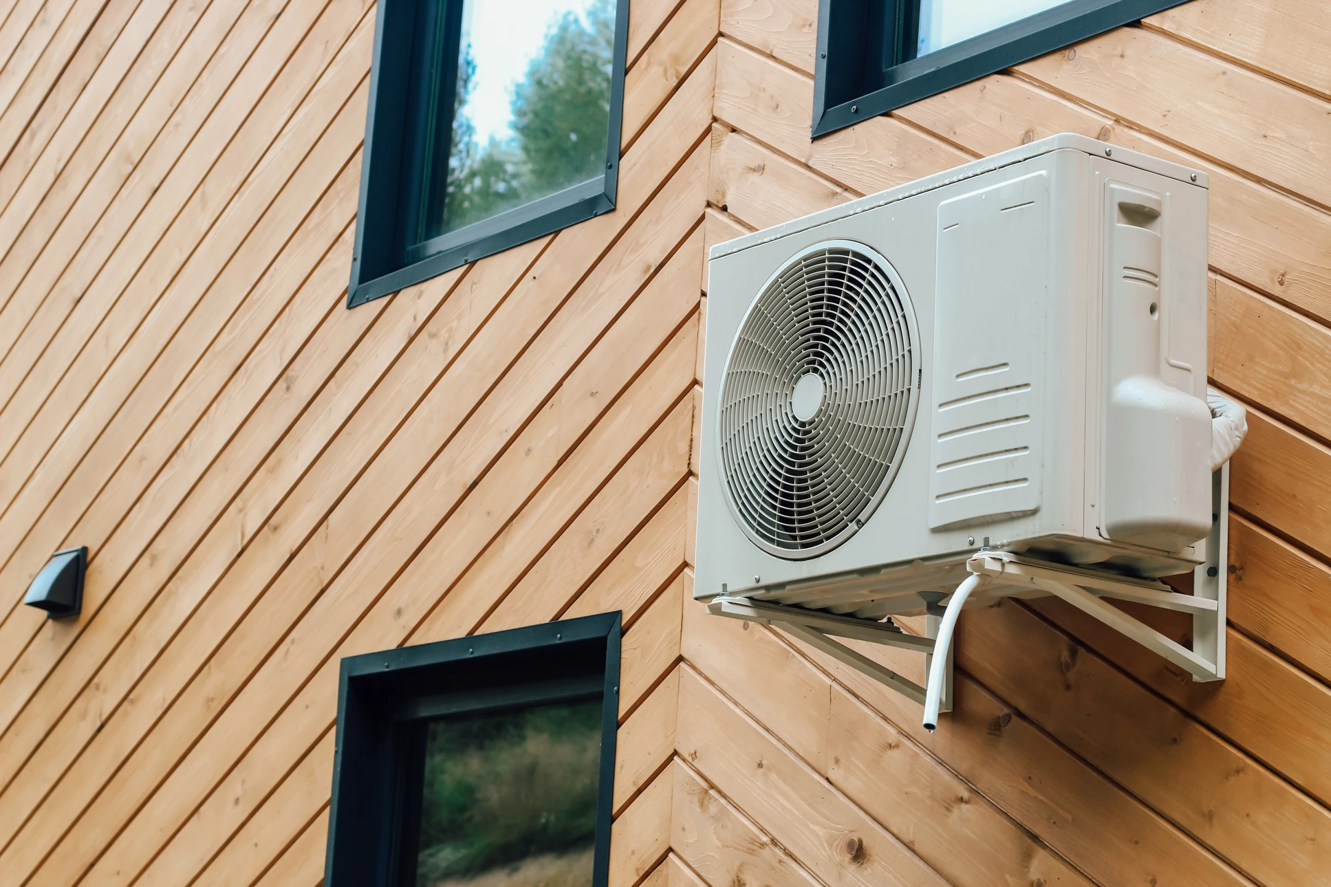 Personne âgée ajustant un thermostat de radiateur à eau chaude dans un intérieur domestique