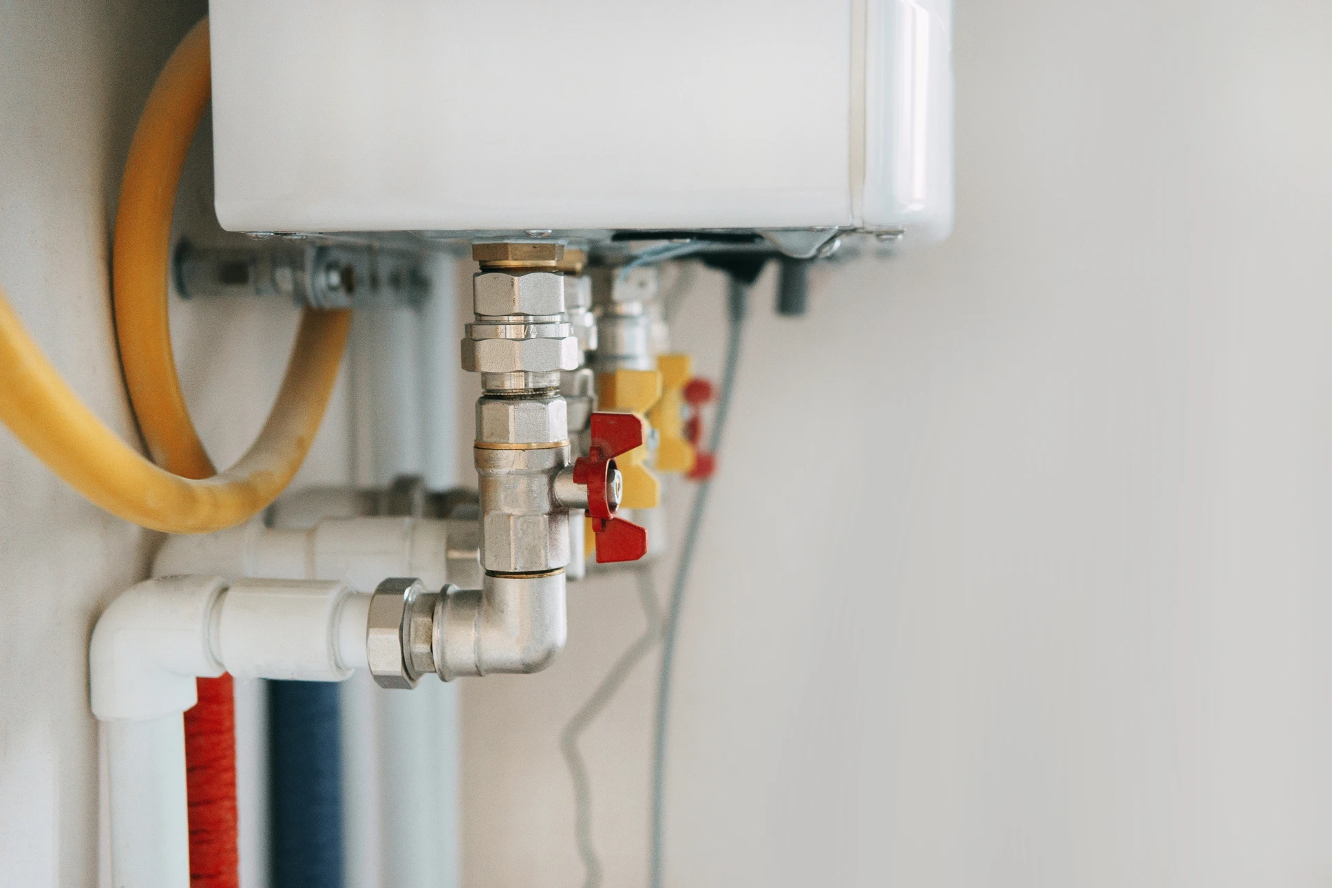 Plombier en uniforme bleu travaillant sur installation de chauffage domestique